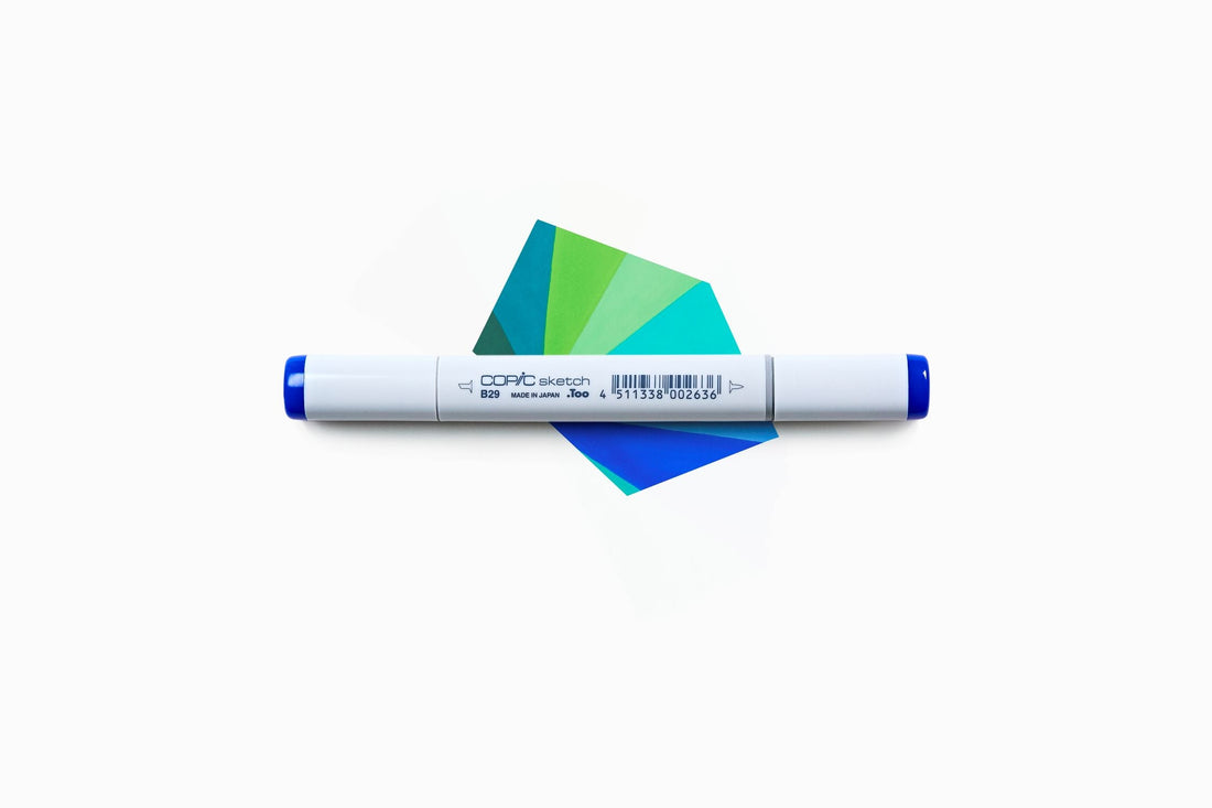 Un pezzo di carta colorato con il Copic Sketch in diverse tonalità di blu e verde
